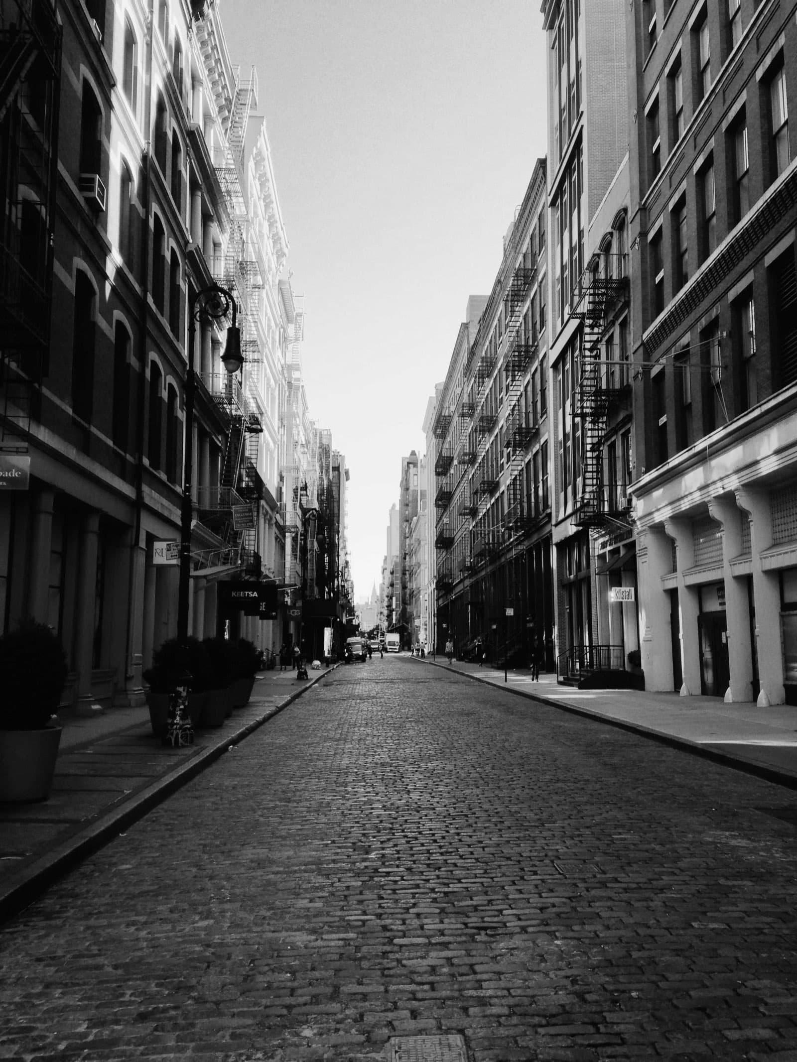 A narrow city street between tall facades, fine-art black and white photograph