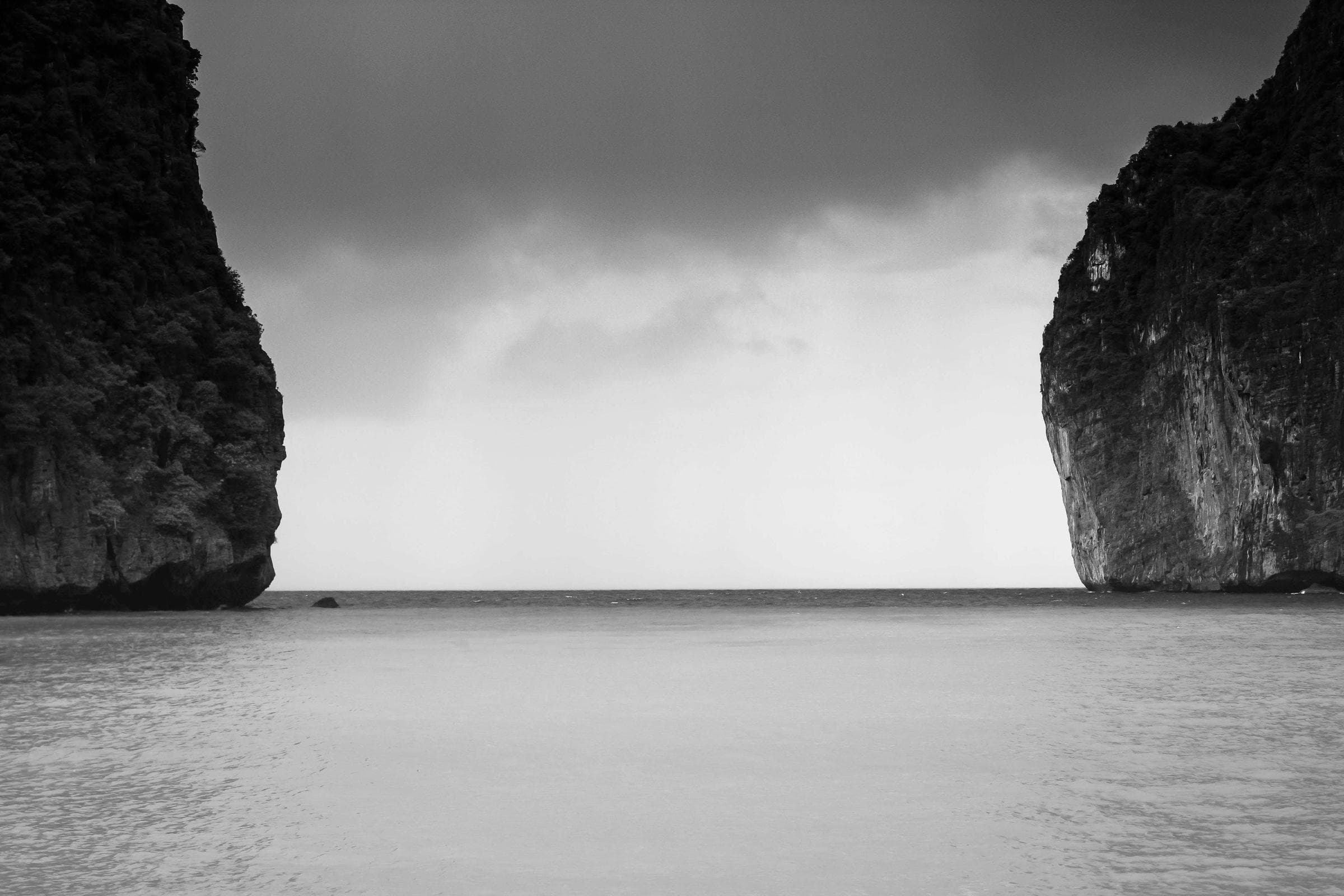 Sea stacks rising from still water in mist, fine-art black and white photograph